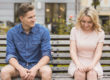 Photo of a couple sitting on a bench together.