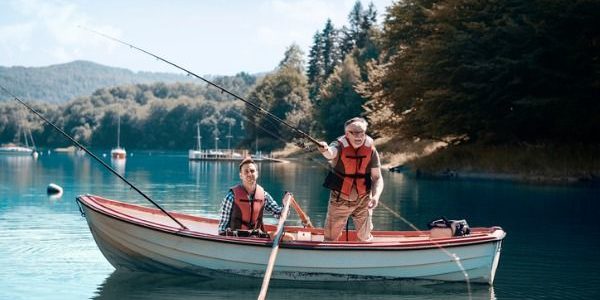 Image of two men fishing in a boat in middle of lake